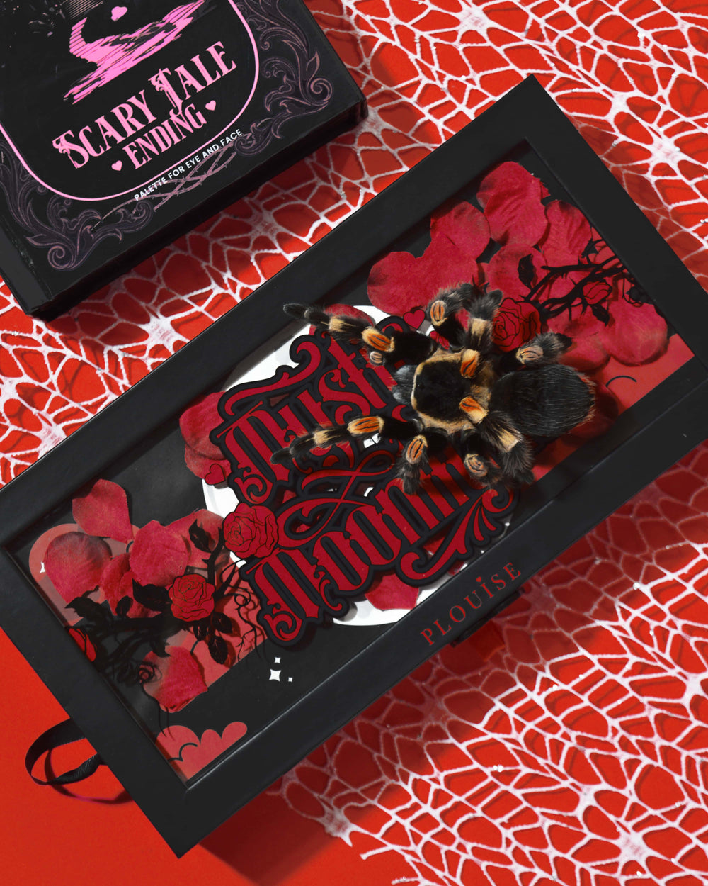 P.Louise Mystic Moonlight Halloween Paleta de sombras de ojos cubierta de pétalos de rosas rojas y una tarántula sobre un fondo de tela de araña roja