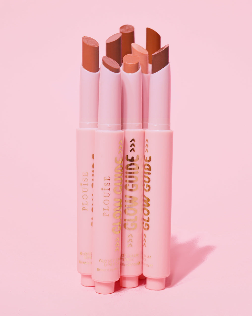 Toma que muestra el bálsamo labial brillante P.Louise Glow Guide completo sin labios mostrando la gama de colores sobre un fondo rosa