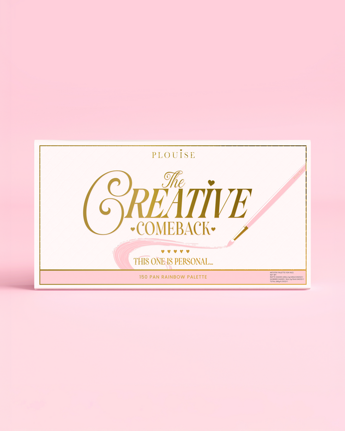 Forsiden af en lukket P.Louise Creative Comeback XXXL Rainbow Eyeshadow Palette med guldtypografi på en pink sag mod en pink baggrund
