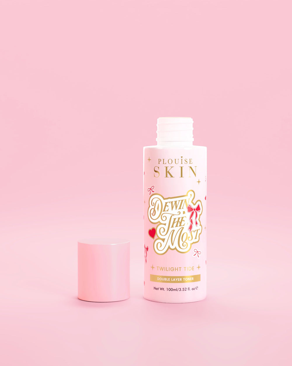 Botella rosa de P.Louise Dewin The MOst Double Layer Toner con diseños de lazos rojos sobre un fondo rosa 