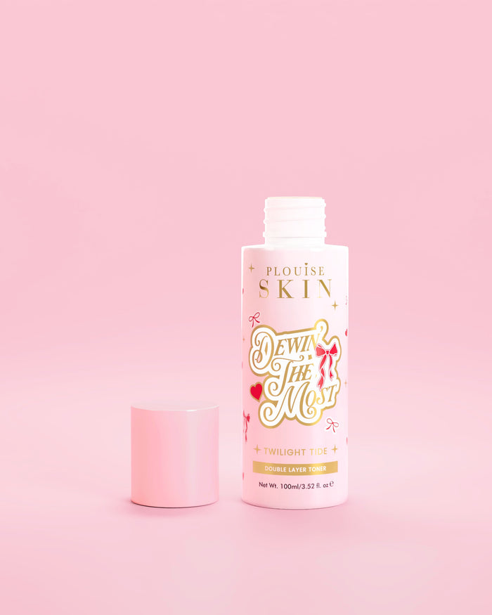 Pink flaske P.Louise Dewin The MOst Double Layer Toner med rød sløjfedesign på en lyserød baggrund 