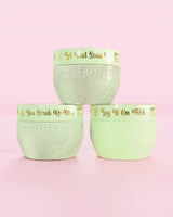 Three P.Louise Hop Into Self-Care Chocolate Covered Strawberries green containers featuring bath salts, body scrub and body butter with gold text on a pink background
