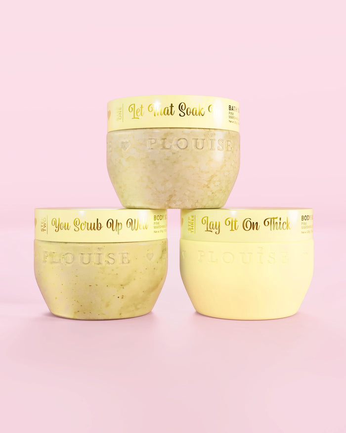 Tre P.Louise Hop Into Self-Care Starwberry Shortcake gule beholdere med badesalt, bodyscrub og body butter med guldtekst på en lyserød baggrund