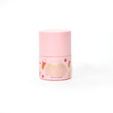 Botella rosa de P.Louise Pass The Plump Lip Treatment sobre un fondo blanco.