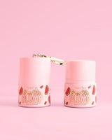 Dos frascos rosas de P.Louise Pass The Plump Lip Treatment con diseño de sandía sobre un fondo rosa