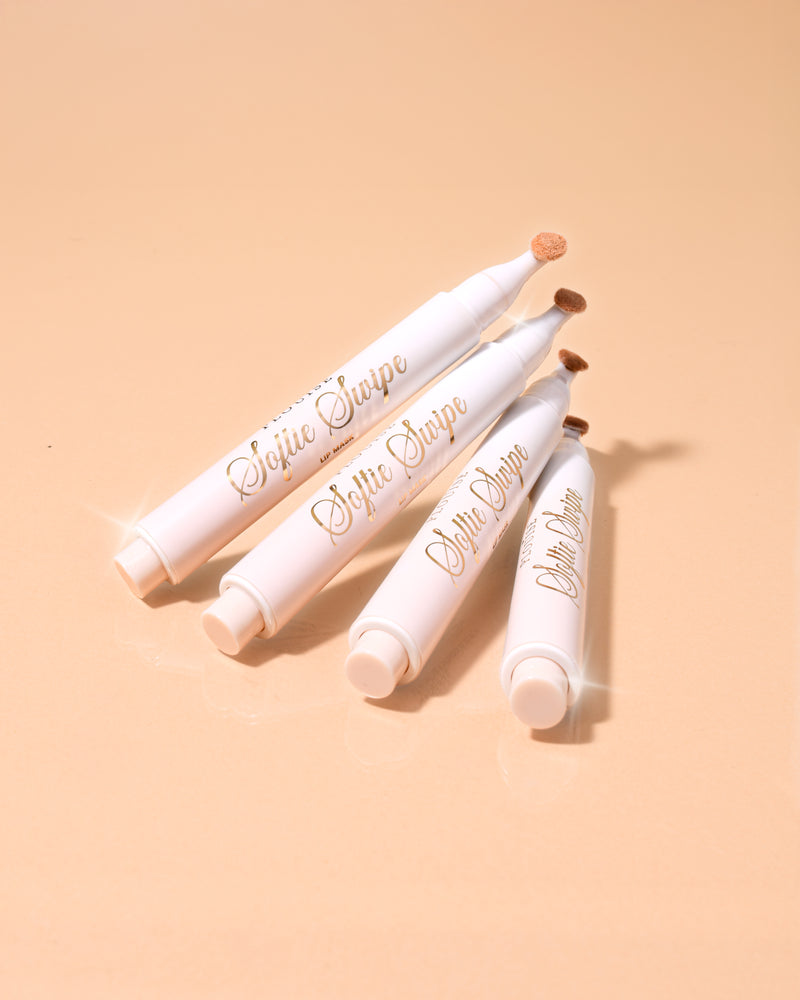 Et billede af fire P.Louise Softie Swipe Tinted Lip Masks i kokosnøddekage duft stablet mod hinanden med en beige baggrund