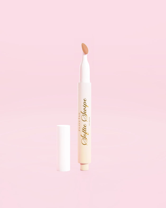 Et billede, der viser P.Louise Softie Swipe Tinted Lip Mask i Barely There nuance mod en lyserød baggrund