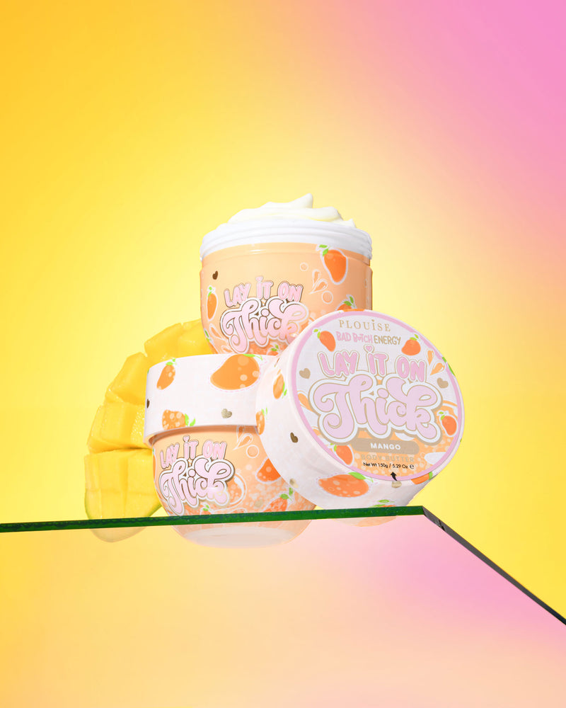 Tre beholdere med P. Louise 'Lift It On Thick' mango body butter på en gradient gul og pink baggrund