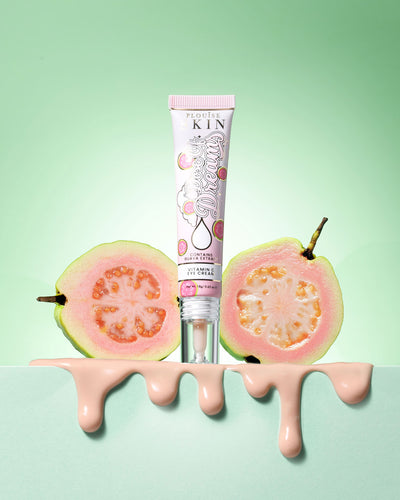 Tube of P.Louise Dose Of Dreams Vitamin C Brightening Eye Cream omgivet af guava frugt på en grøn baggrund