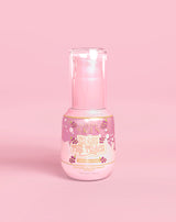Botella rosa de P. Louise Erase The Trace Dark Spot Correcting Serum sobre un fondo rosa