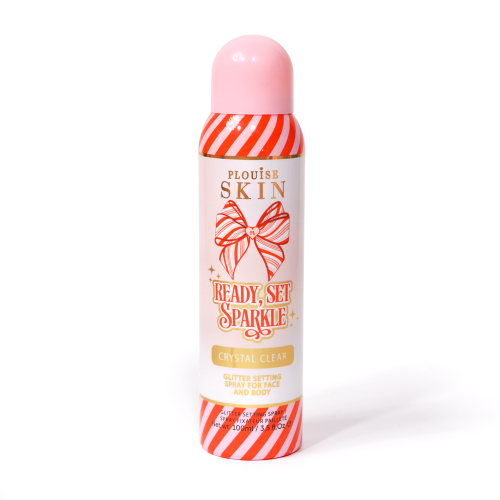 Una botella de spray fijador P. Louise Ready Set Sparkle Christmas Glitter con rayas rojas y rosas en la botella y un lazo a rayas rojas y rosas sobre un fondo blanco.