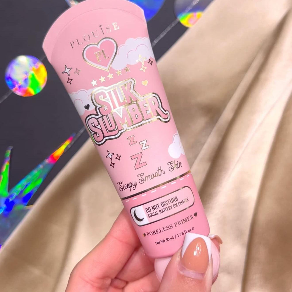 En person, der holder en tube P.Louise Silk Slumber Poreless Primer med en lyserød baggrund og kosmetiske produktdetaljer.