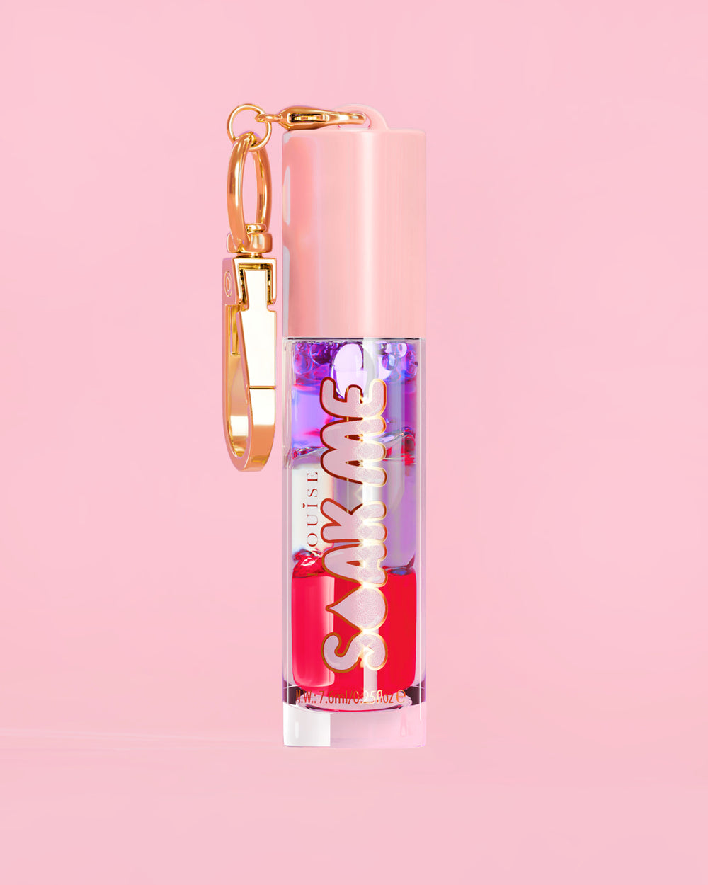 P. Louise Soak Me Lip Oil con aceite en capas de colores en un tubo rosa con un cierre dorado sobre un fondo rosa